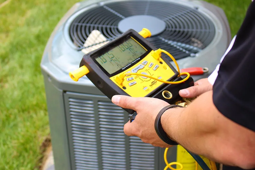 Outdoor air conditioning unit being serviced by a Parkersons technician